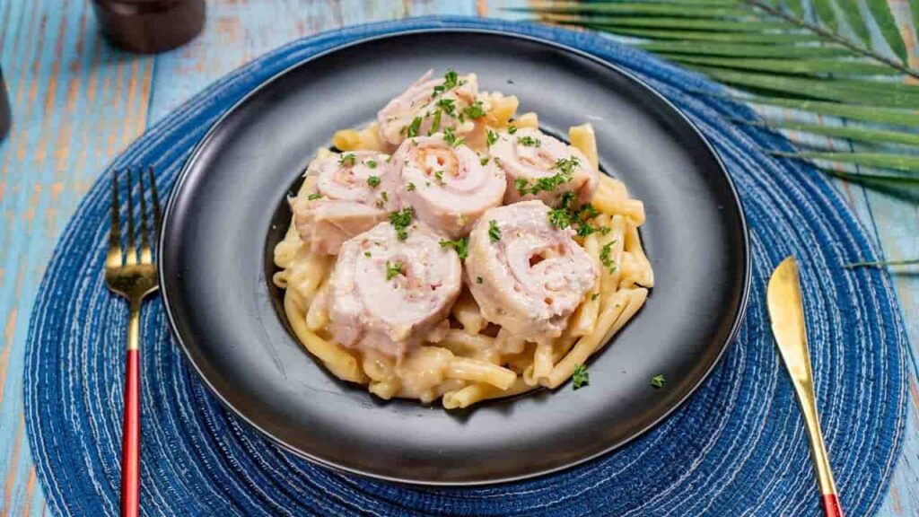 “Plated serving of Chicken Cordon Bleu Crock Pot with chicken, ham, melted Swiss cheese, stuffing topping, mashed potatoes, and green beans”