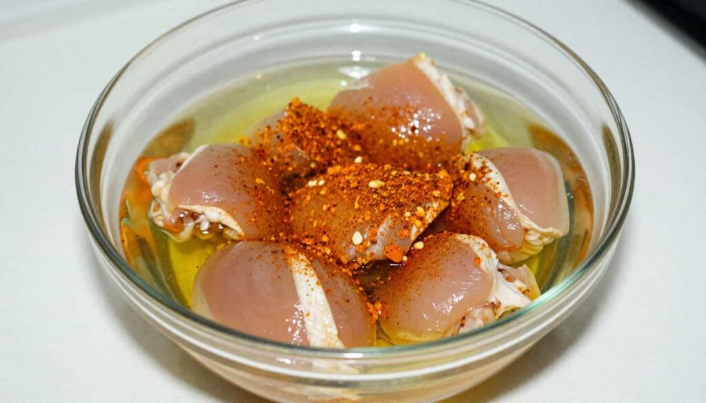 “Chicken marinating in Old Bay seasoning with oil and lemon.”
